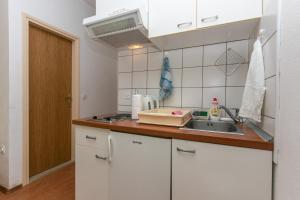 布雷拉Studio Brela 6907c的厨房配有白色橱柜和水槽