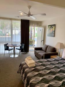 卡尔斯Seahorse Motel Cowes的酒店客房配有床、桌子和沙发。