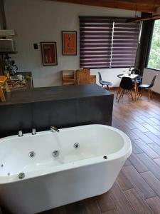 马萨米特拉Mazamitla Pinos del Rio的一个带桌子的房间内的白色大浴缸