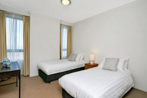 悉尼ALF49-Huge 2BR Penthouse Style, Great Water Views的酒店客房设有两张床和窗户。