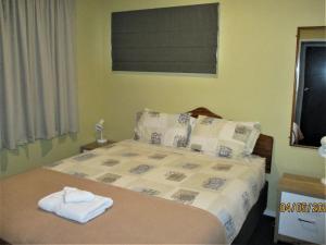 皇后镇Spectacular Lake & Mountain Views的一间卧室配有带毛巾的床