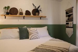 拉戈斯德莫雷诺CASA MADERA的一张带绿色和白色床单及枕头的床