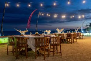 克拉玛斯Desa Swan Villas & SPA, Keramas的海滩上晚上的一组桌子