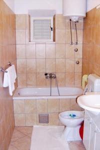维甘Apartment Viganj 633c的带浴缸、卫生间和盥洗盆的浴室