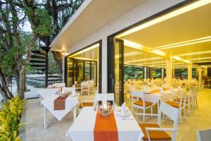 象岛SYLVAN Koh Chang的餐厅设有白色的桌椅和窗户。
