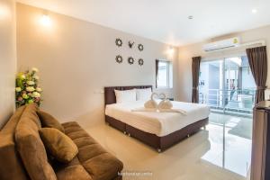 北碧Makan Resort的一间卧室配有一张床和一张沙发