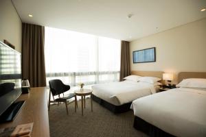 釜山海云台贝斯特韦斯特酒店的酒店客房配有两张床和一张书桌