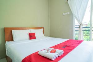 BojonegoroRedDoorz Plus Syariah At Lotus Hotel Bojonegoro的一间卧室配有一张床,上面有两条毛巾