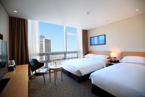 釜山海云台贝斯特韦斯特酒店的酒店客房设有两张床和大窗户。