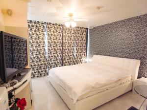 神户V酒店（仅限成人）的卧室配有白色的床和电视
