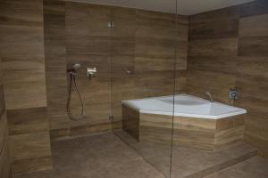 奥洛穆茨乌克拉斯库餐馆旅馆的设有带白色浴缸的淋浴的浴室