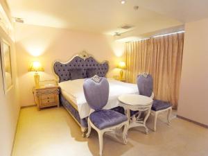 神户V酒店（仅限成人）的一间卧室配有一张床、两把椅子和一张桌子