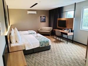 新山NB HOTEL的配有一张床和一张书桌的酒店客房