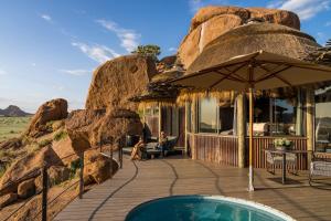 TwyfelfonteinCamp Kipwe的一个带游泳池和遮阳伞的度假胜地