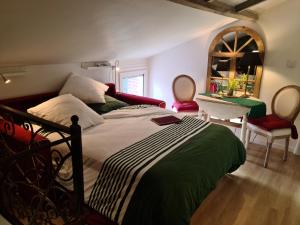 吉维尼Le petit nid d'aigle - Giverny的一间卧室配有一张床、一张桌子和一面镜子