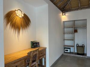 乌鲁瓦图Santana Villas Bingin的客房设有一张木桌,墙上装有风扇