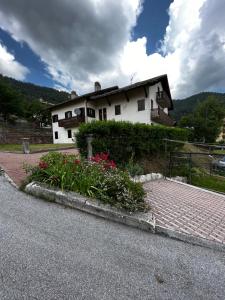 福尔加里亚Trentino Apartments - Casa Laita的路边花朵的白色房子