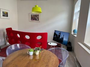 圣戈阿尔Good times in St. Goar (Mit Fahrrad-Keller)的客厅配有木桌和红色椅子