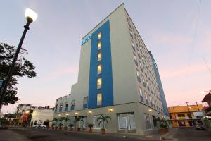 比亚埃尔莫萨比亚埃尔莫萨中心One酒店的一边有蓝色条纹的建筑