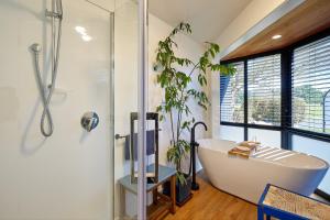 凯库拉美景客房公寓的一间带白色浴缸和植物的浴室