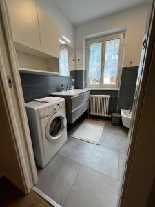 福尔加里亚Trentino Apartments - Casa Laita的一间带洗衣机和水槽的浴室