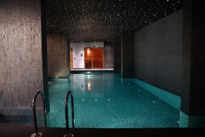 伊斯坦布尔Galata's Hotel的一个带蓝色瓷砖地板和楼梯的游泳池