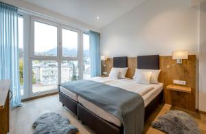 巴特莱辛哈尔巴特赖兴哈尔阿瓦隆酒店的一间卧室设有一张大床和大窗户
