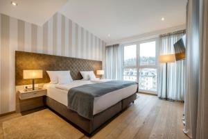 巴特莱辛哈尔巴特赖兴哈尔阿瓦隆酒店的一间卧室设有一张大床和一个大窗户