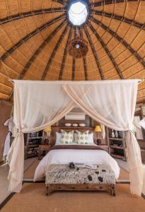 TwyfelfonteinCamp Kipwe的一间帐篷内带天蓬床的卧室