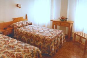 埃赫阿-德洛斯卡瓦列罗斯夸特洛埃斯奎因纳斯旅馆的酒店客房设有两张床和一张桌子。