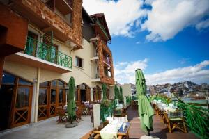 塔那那利佛Palissandre ANTANANARIVO的配有绿色遮阳伞和桌椅的酒店