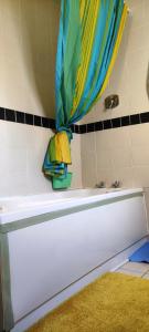 约尔Key Locker by WhatsApp , Joanna's Little Studio, Own entrance, Own Bathroom的一间带毛巾和浴帘的浴缸的浴室