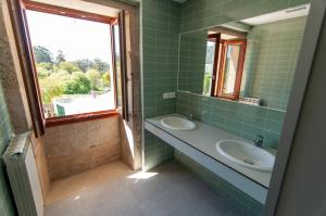 AmésA Casa Do Boi的绿色瓷砖浴室设有水槽和窗户