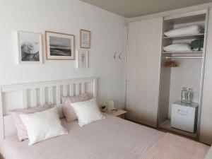 奥斯坦德Sea-Me Ostend的一间卧室配有带白色床单和粉红色枕头的床。