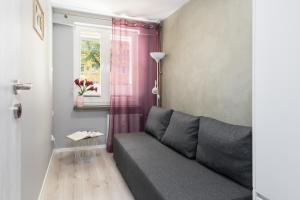 波兹南Family Apartment Poznań Rataje by Renters的客厅设有灰色的沙发和窗户。