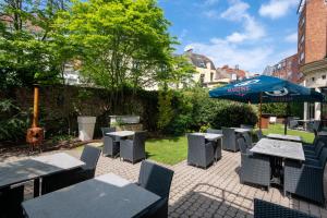 布鲁塞尔马丁布鲁塞尔欧盟酒店的一个带桌椅和遮阳伞的庭院