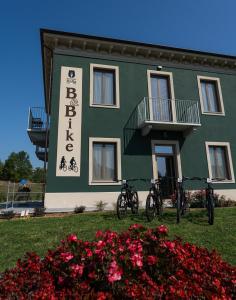 Mombello MonferratoB & Bike di Ristorante Italia的一座绿色建筑,前面停放着自行车