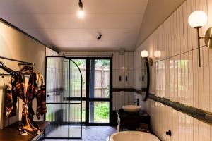 斯库库扎Kruger Shalati - Train on The Bridge & Garden Suites的带浴缸、水槽和窗户的浴室