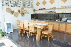 明古鲁省Pringgading Surf Camp Mitra RedDoorz的厨房配有木桌和椅子