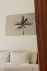 龙目岛库塔龙目岛斯卡拉酒店的一张床上方棕榈树的照片