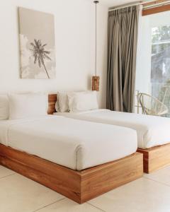 龙目岛库塔龙目岛斯卡拉酒店的卧室设有两张单人床和白色墙壁。