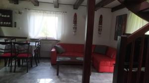 Skoszewo4 Pory Kaszub - Domek z banią i sauną的客厅配有红色的沙发和桌子