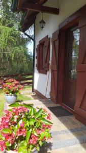 Skoszewo4 Pory Kaszub - Domek z banią i sauną的门廊上开满鲜花的房子的门