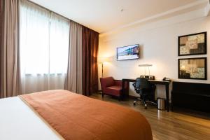 卡萨诺韦米兰马尔彭萨机场皇冠假日酒店的酒店客房配有一张床、一张书桌和一台电脑