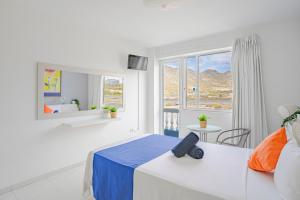 GuazaHostel Neon Tenerife的白色的卧室设有床和窗户