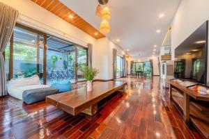 会安Puravida Villa Hoi An 2的客厅配有桌子和沙发