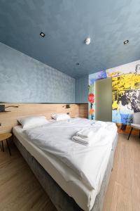 考普堡Jam Panzió的卧室配有一张白色大床,墙上挂有绘画作品
