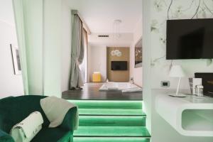 米兰蒙特拿破仑大道套房酒店的客厅配有绿色椅子和电视