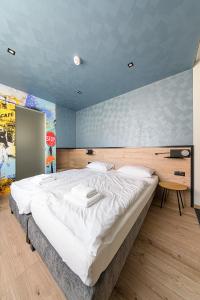 考普堡Jam Panzió的一间设有一张大床的卧室,位于一个设有停车标志的房间