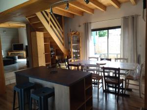 卢登维耶尔Maison familiale au centre de Loudenvielle的厨房以及带桌椅的用餐室。